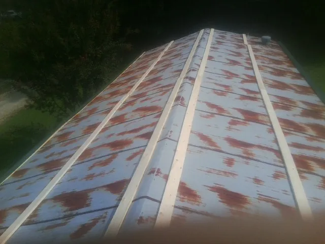 Rusted metal roof panels with new wood purlins before replacement — Storm Damage Roof Repair in Valley Center by Roofing Brothers