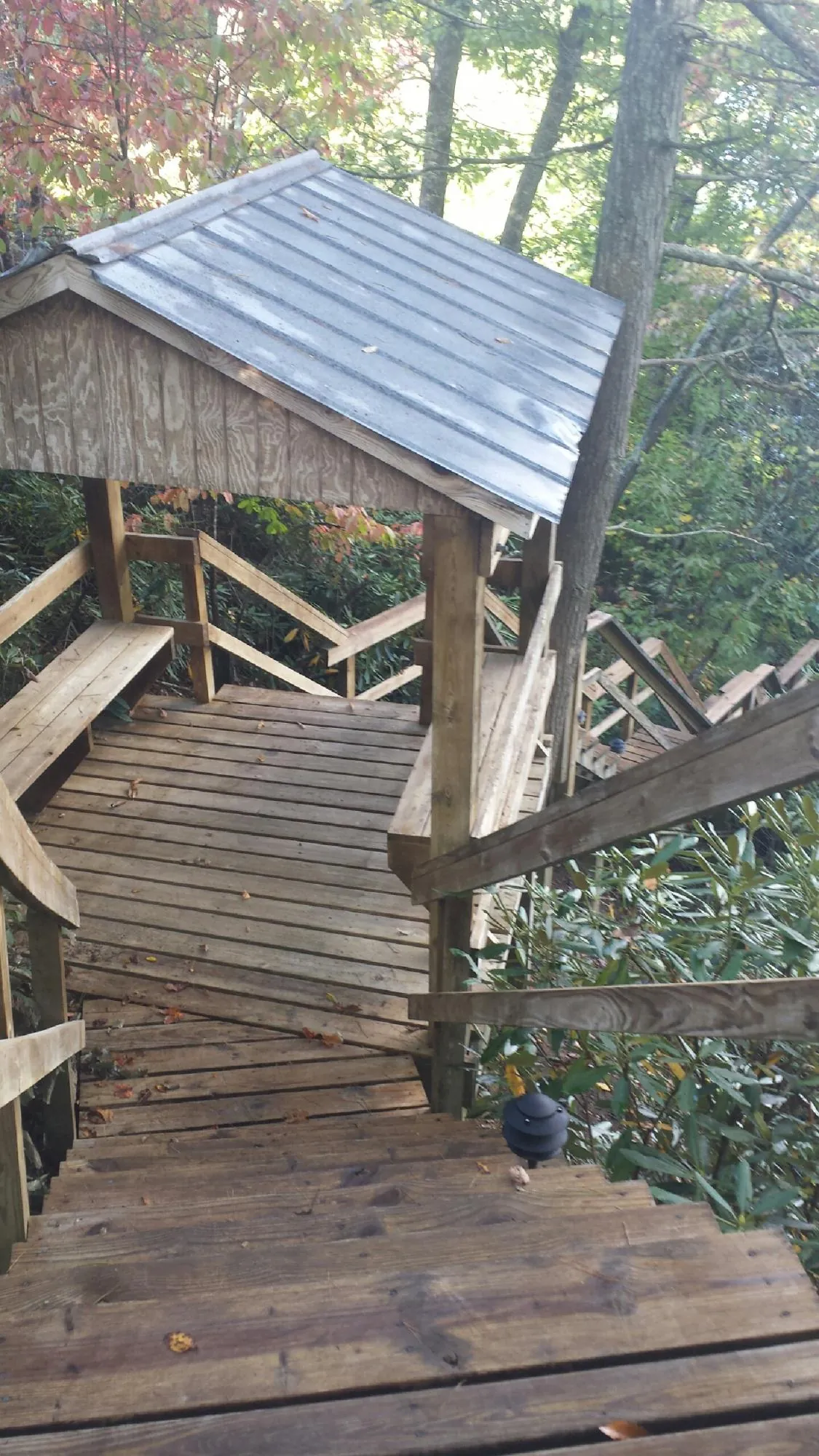 Metal roofed shelter over wooden steps on a wooded walkway — Skylight Repair & Installation work by our crew in Valley Center